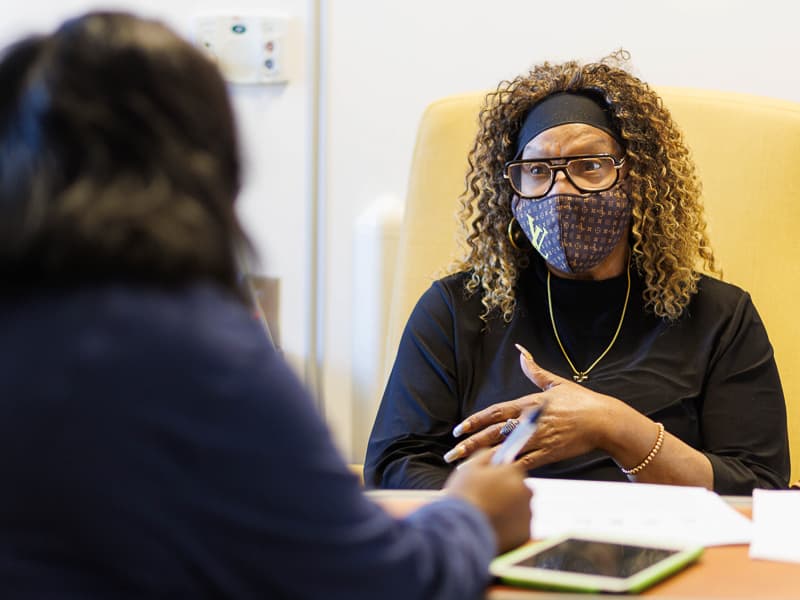Gloria Banks of Jackson, right, a participant in UMMC's RECOVER Long COVID-19 trial, answers questions from clinical research coordinator Kia Jones in the Medical Center's Clinical Research and Trials Unit.