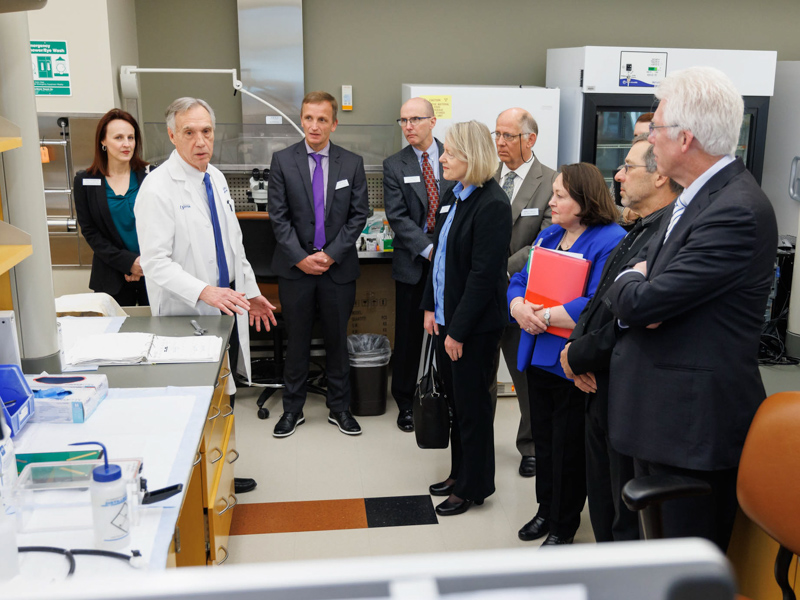 Dr. John Hall, second from left, chair of the department of physiology and biophysics, leads a tour of the Guyton Research Complex during a recent SACS visit as Dr. Mitzi Norris, third from right, in blue, looks on with members of the site team.