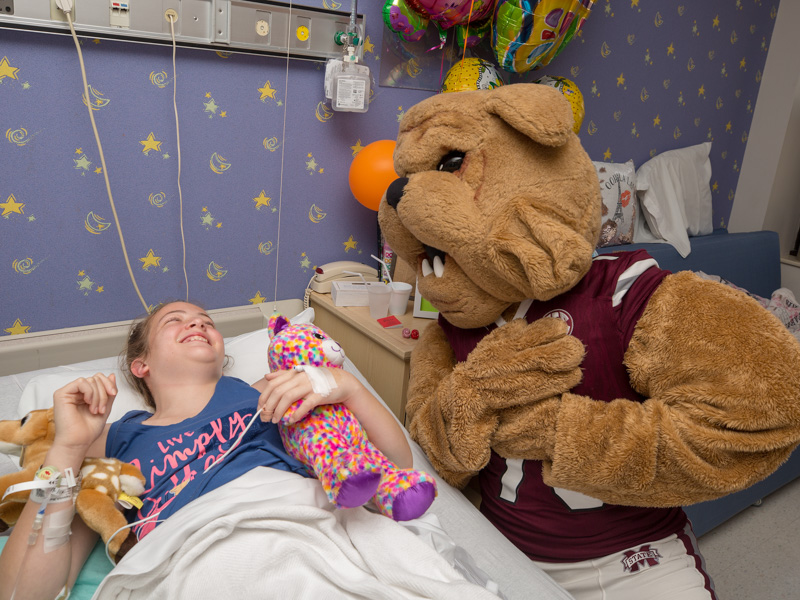 JoJo Dodd as Bully stops by the bedside of Malorie Franovich of Pascagoula during a July 2018 visit to Batson Children’s Hospital by Mississippi State University's football team. Dodd came out of retirement to become Bully for the patients at the hospital.