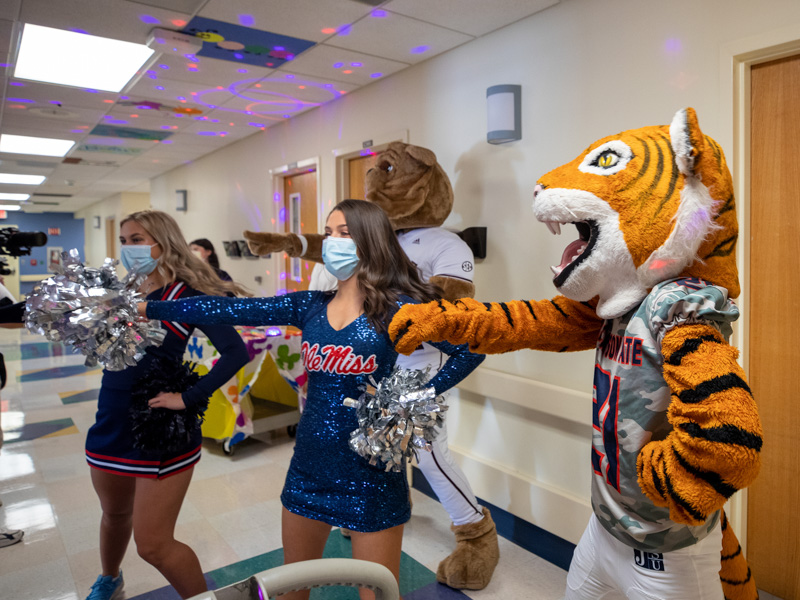 Cheering on Children's of Mississippi patients Saturday are cheerleader Mara Liston and dancer Jane Granberry of Ole Miss, Bully from Mississippi State and Sonny Thee Tiger of Jackson State University. Jay Ferchaud/ UMMC Communications