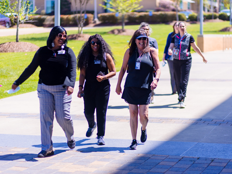 UMMC employees share a laugh while walking around campus during National Walking Day Friday. Lindsay McMurtray/ UMMC Communications