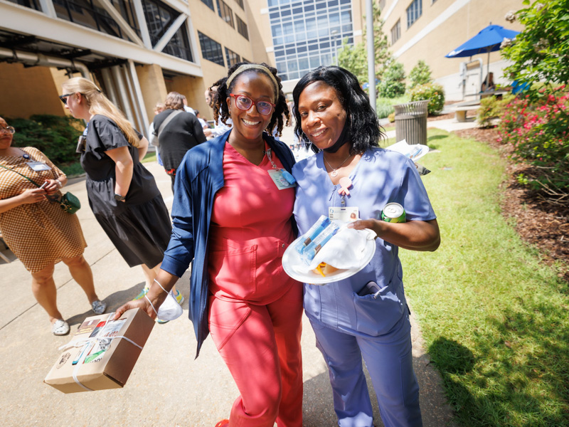 Registered Nurses Sebrina Brown, left, and Carla Roby, enjoy food and activities on the Guyton Building breezeway on Wednesday.