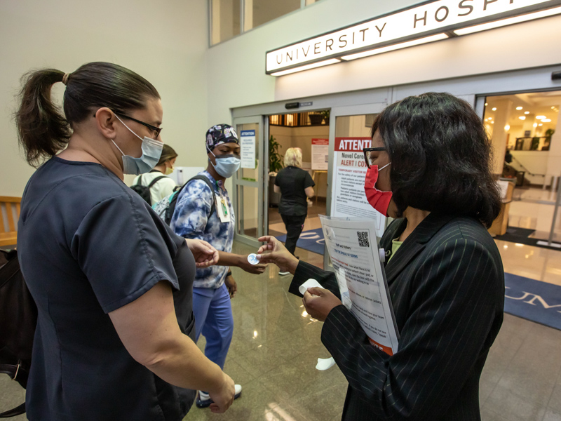 Chief Nursing Executive Kristina Cherry hands out stickers to University Hospital Respiratory Therapists Melissa June, left, and Natasha Russell as part of World Hand Hygiene Day. Melanie Thortis/ UMMC Communications 