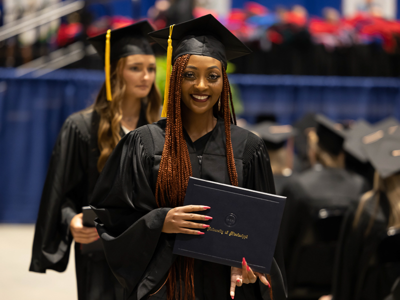 Kiana Jones shows her Bachelor of Science in Radiologic Sciences degree as she exits the stage during commencement ceremonies.