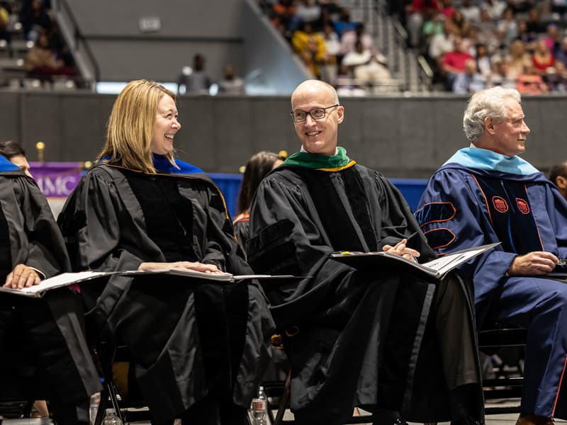Dr. Natalie Gaughf, assistant vice chancellor for academic affairs, and Dr. Scott Rodgers, associate vice chancellor of academic affairs, share a laugh during commencement.