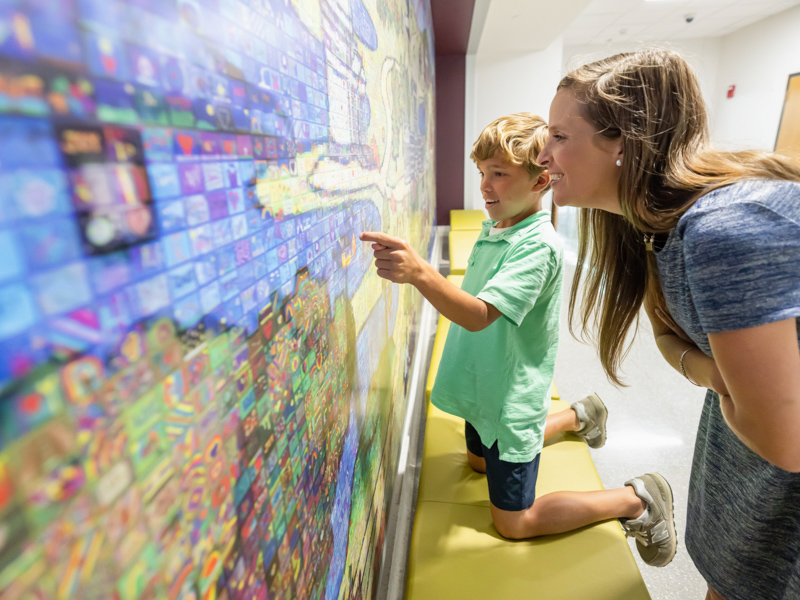 Kristel Robinson and her son, Aiden, of Brandon admire the many mini works of art that make up the Sanderson Tower's new mosaic mural. Melanie Thortis/ UMMC Communications