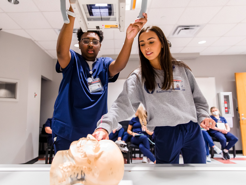 Radiologic Science students Marquis Moore and Anna Llyod line up the x-ray machine during a lab.
