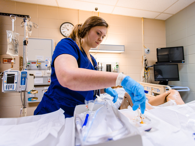 Ailee Stapleton prepares her supplies before inserting a foley catheter for a manikin during a School of Nursing skills relay.