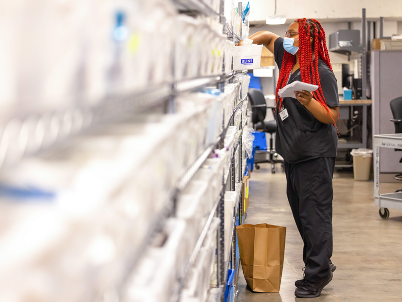 Supply technician Madison Roberts fulfills an order in Shipping and Receiving. Melanie Thortis/ UMMC Communications