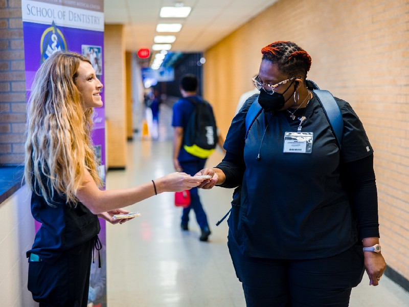 Lauren Thames, left, a fourth-year School of Dentistry student, offers one of her home-baked cookies to Latasha Jones, a unit secretary in the Department of Obstetrics and Gynecology.