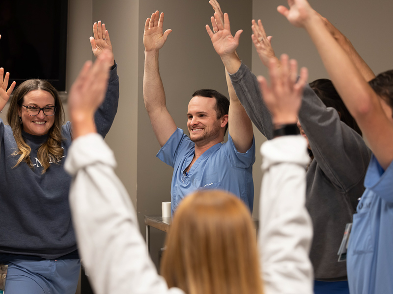 Registered nurses Kelly Holly and T.J. Temple take part in a 15-minute yoga session offered by the Office of Well-being at the Cardiovascular Intensive Care Unit.