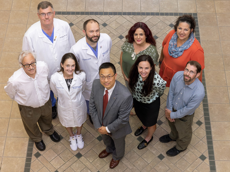 Dr. Lei Zhang, center, joined by co-investigators on the VIP program, left, and intimate partner violence initiative, right. Pictured are, front row, from left, Dr. Bill Hillegass, Vearrier, Zhang, Dr. Erin Dehon and Dr. Andrew Voluse. Back row, from left, are Dr. Carl Mangum, Kutcher, Dr. Masoumeh Karimi and Dr. Tara Price. Jay Ferchaud/ UMMC Communications