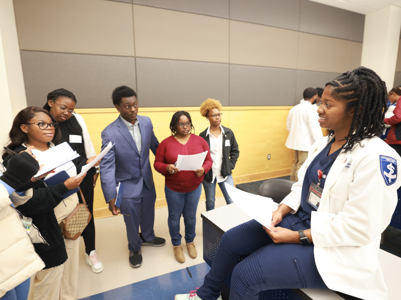 Fourth-year medical student Amia Green of Byram, acting as a patient, answers questions posed by Jackson State University students participating in Pre-Med Day in JSU'S College of Science Engineering and Technology Building. "This was an amazing opportunity to reach out, and I hope this type of event continues for other schools across the state," Green said. (Photo courtesy of William H. Kelly III/JSU University Communications)