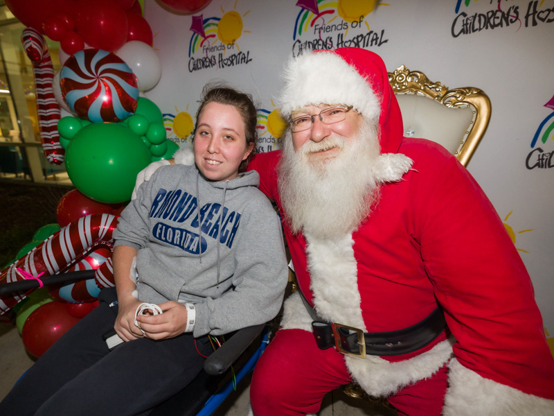 Children's of Mississippi patient Hannah White of Carthage smiles for a photo with Santa during BankPlus Presents Light-A-Light.