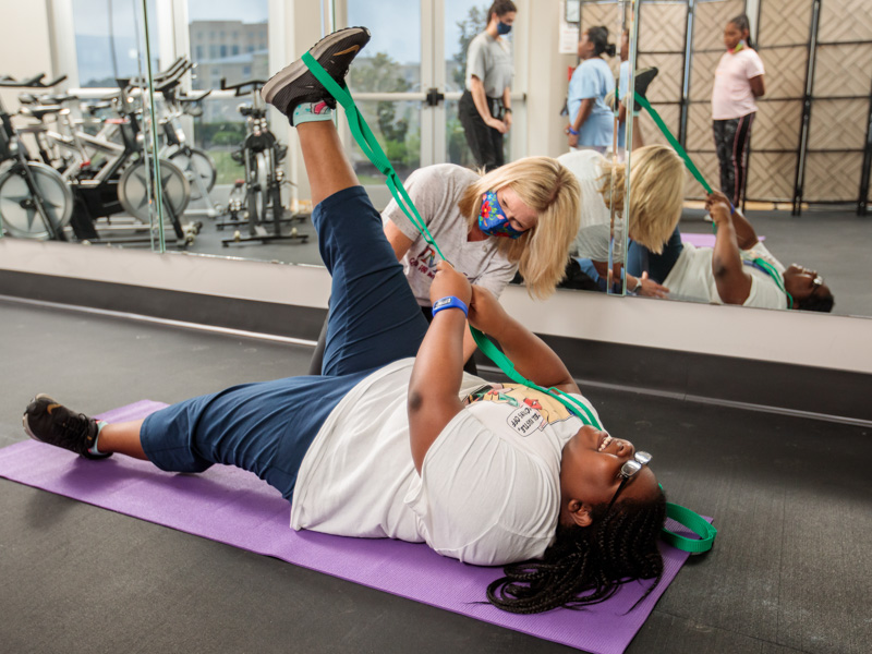 Physical therapist Rachel Dear watches as Danayia Cox completes a round of exercises during a 2021 Iron Kids session.