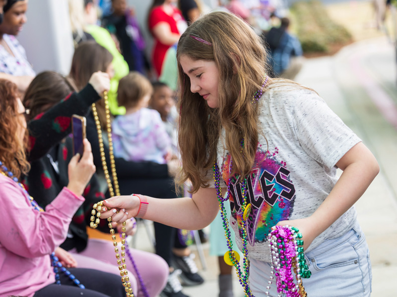Children's of Mississippi patient Selah Readman of Florence gathers Mardi Gras beads during the Mississippi Department of Public Safety parade at the Kathy and Joe Sanderson Tower Tuesday. Melanie Thortis/ UMMC Communications 