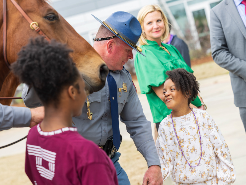 Mississippi Highway Patrol Captain Wayne Wasson Jr. talks with Children's of Mississippi patient Lori Webster of Natchez as Mississippi First Lady Elee Reeves looks on. Melanie Thortis/ UMMC Communications 