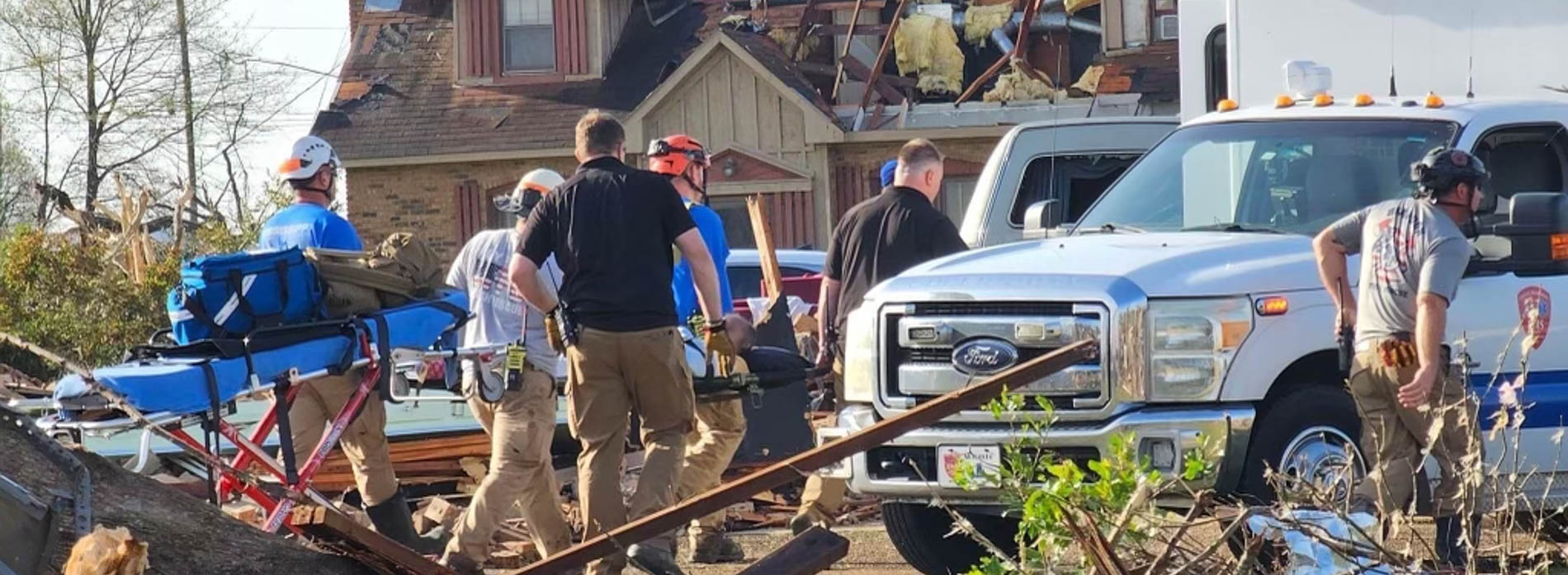 Mississippi Center for Emergency Services staff Will Appleby, center in black shirt, and Jeremy Benson, in black shirt to Appleby's right, help in search and rescue efforts at a Rolling Fork home.