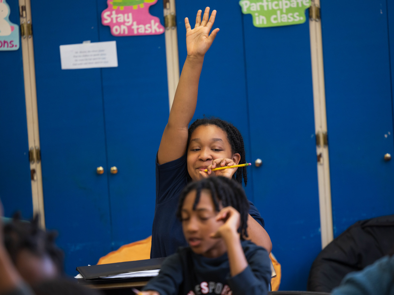 Isabella Burrell, a 4th grader at Barack H. Obama Magnet Elementary School in downtown Jackson, raises her hand to answer a question during Mack's lesson on light.