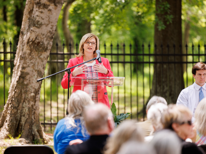 Dr. LouAnn Woodward, vice chancellor for health affairs and dean of the School of Medicine, recites the inscription on a monument to the body donors in the UMMC Cemetery: "By their extraordinary gifts, these dead have taught the living how to touch. Through them, we touch the body of the world.”