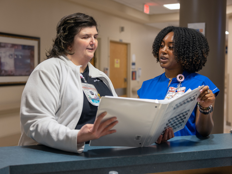 Renee Ballard, a nurse educator on 4 North, talks with Tanzi McAllister, who will graduate from UMMC's School of Nursing's traditional BSN program in May.