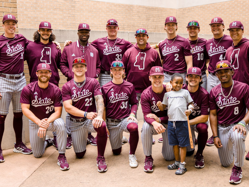 Mississippi State baseball players smile after playing ball with Children's of Mississippi patient Jayceston Harris of Waynesboro. Lindsay McMurtray/ UMMC Communications 