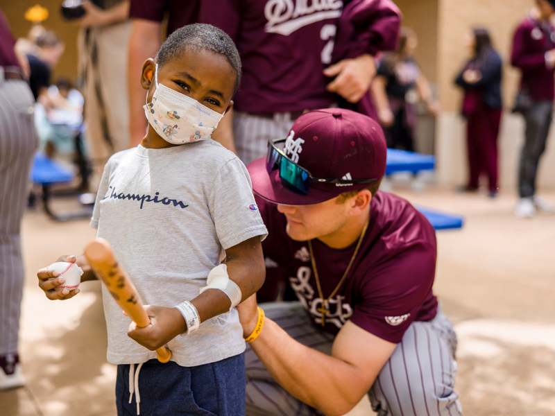 Children's of Mississippi patient Jayceston Harris of Waynesboro gets his T-shirt signed by Mississippi State baseball players during their visit to the state's only children's hospital. Lindsay McMurtray/ UMMC Communications 