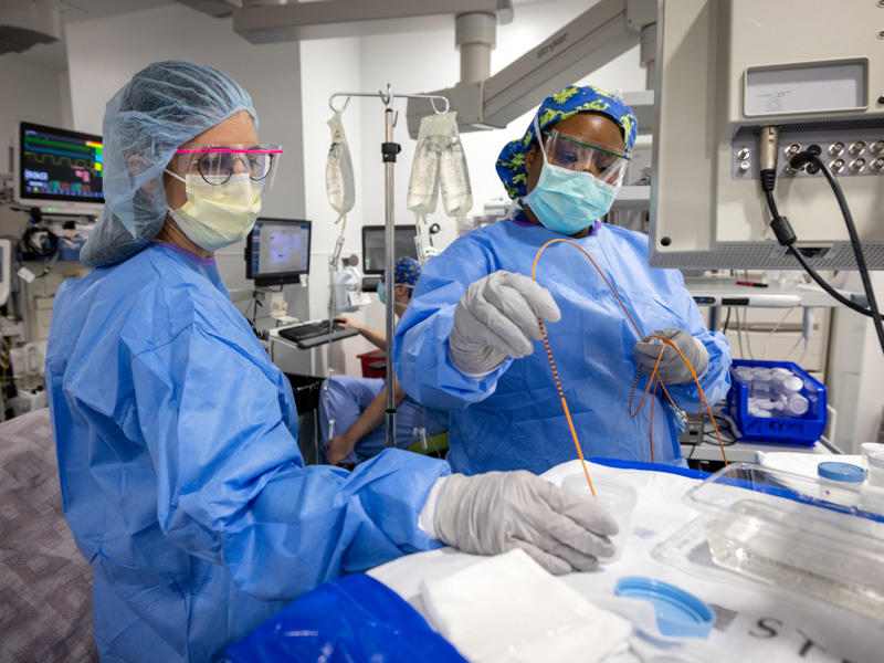 Dr. Sandra Camacho, left, assistant professor of pediatric gastroenterology, and surgical tech Derexie Cosby gather a sample for research.