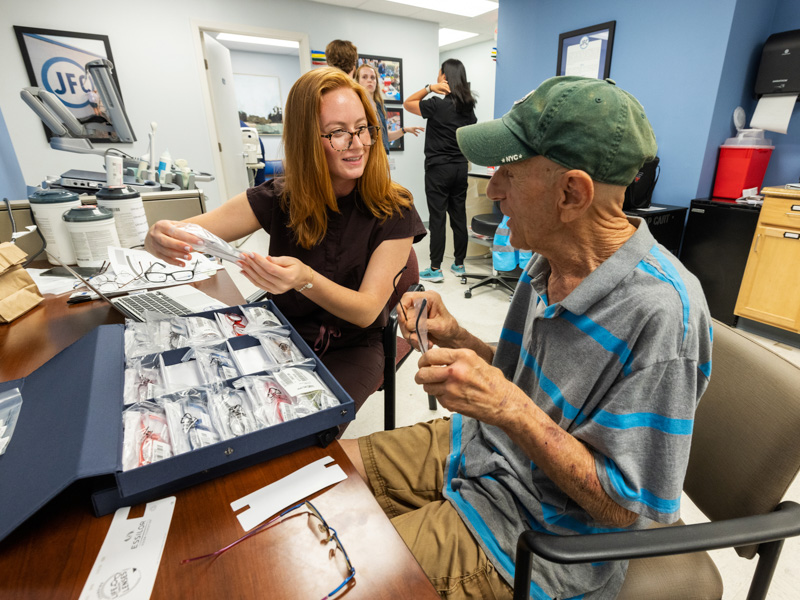 Third-year School of Medicine student Riley Brown, left, helps JFC Vision Clinic patient Paul Pappas of Jackson choose frames for his new eyeglasses.