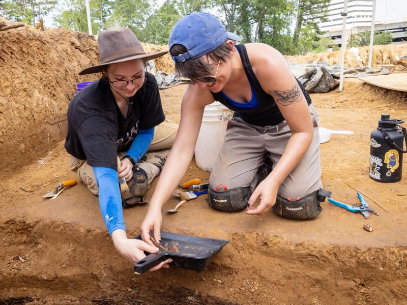 McKenna Snyder, a student at the University of Dundee in the U.K., and Abbie Schroeder, a University of Kansas graduate, sift out material discovered in one of the Asylum Hill graves. Jay Ferchaud/ UMMC Communications