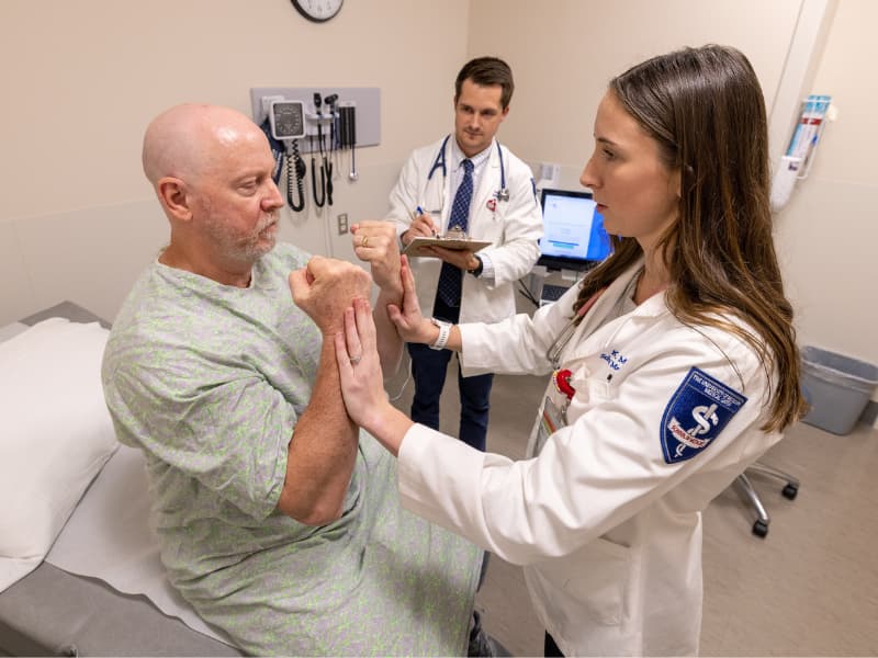 Medical Kayla Lovitt and Stephen Weathersby, Jr. examine and interview Standardized Patient Terry Winstead; this simulated clinical experience will be afforded M1s and M2s when the curriculum design is in place.