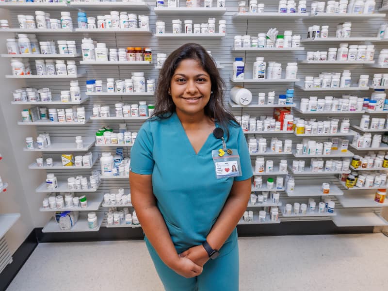 Pharmacist Drashti Upadhyay stands in front of the day’s inventory at Central Pharmacy.