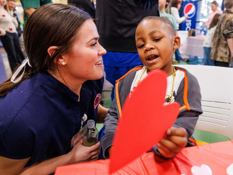 Children's of Mississippi patient Telvin Holmes Jr. of Liberty shows his Valentine's Day artwork to student nurse Ava Kump. Jay Ferchaud/ UMMC Photography 