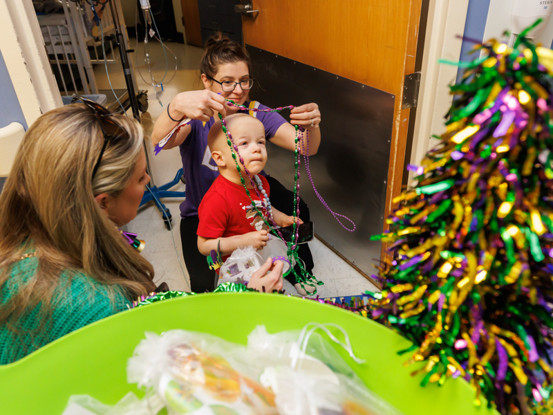 Children's of Mississippi patient Jacob Warren of Meridian gets beads from his mom, Marsha Warren, during a Friends of Children's Hospital Mardi Gras parade. Melanie Thortis/ UMMC Photography 