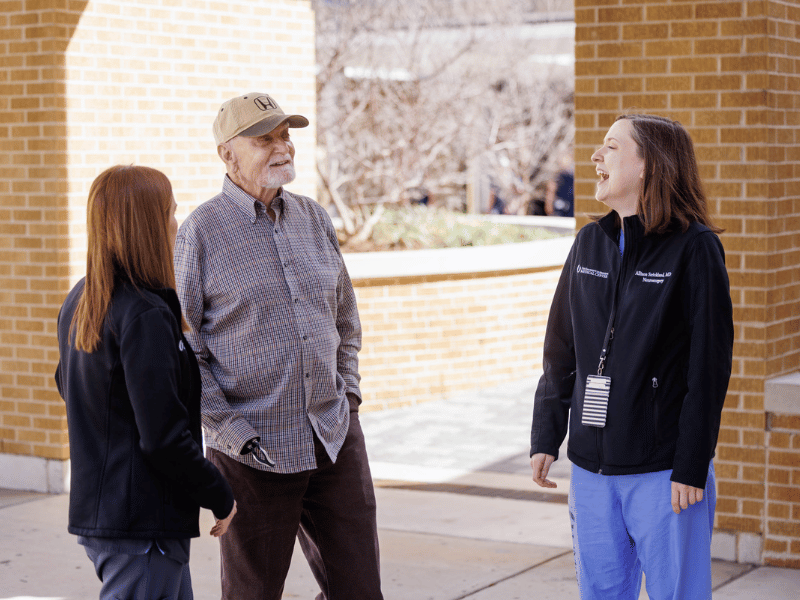 Aaron Cummins shares a laugh with Mackenzie Cook, his granddaughter and nurse practioner in the Department of Neurosurgery, left, and Dr. Allison Strickland, neurosurgeon and family friend.