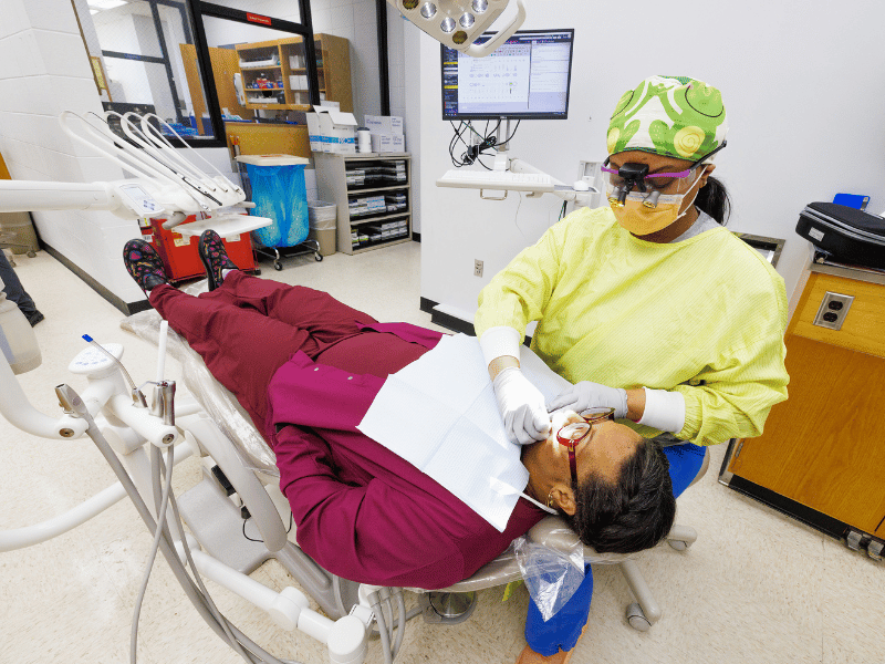 Teleshia Johnson, fourth-year dental student, examines patient Tonjula Mason.