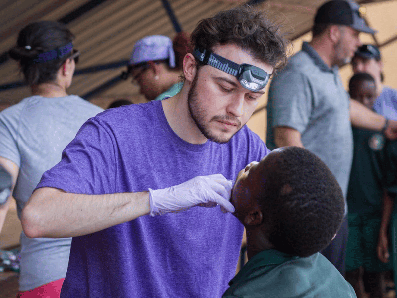 Ivy performs cleanings for children during a dental mission trip to Togo, Africa.