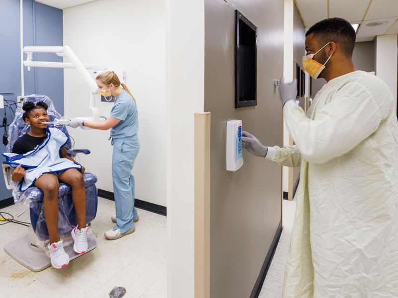 Devon Coleman, fourth-year dental student, and pediatric resident Dr. Chauncey Blakeney take X-rays with Kennedy Pomerlee, 9, of Byram.