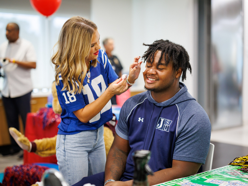 Jackson State University defensive lineman Jeremiah Williams smiles while getting a temporary tattoo during a Friends of Children's Hospital Tailgate Party at Children's of Mississippi.