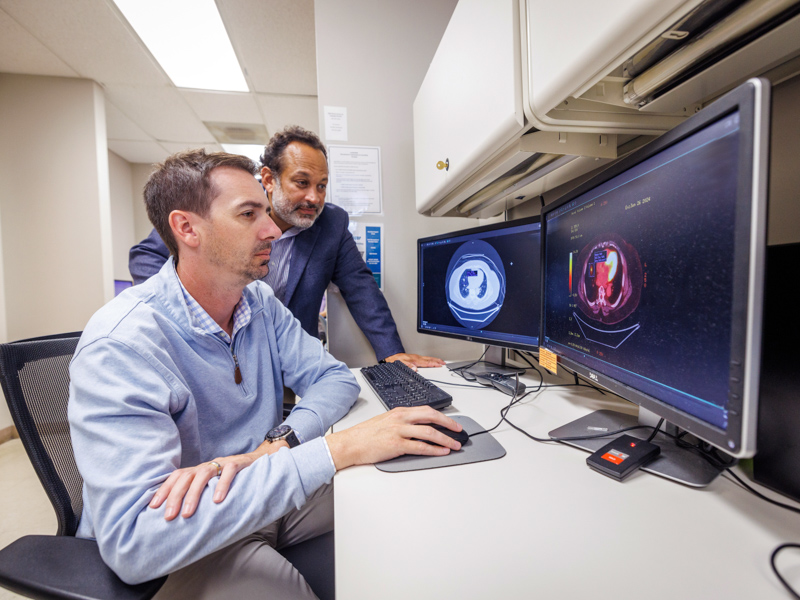 Dr. Pierre de Delva, UMMC division chief of General Thoracic Surgery and chair of the Mississippi Lung Cancer Roundtable and Dr. Jonathan Hontzas, assistant professor in the School of Population Health and director of the ACT Center and Lung Cancer Screening Program at UMMC, view a low-dose CT scan, the only proven lung cancer screening tool.