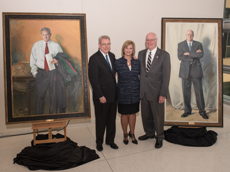 Former vice chancellors Dr. Dan Jones, left, and Dr. James Keeton, right, are joined by their successor and friend, Dr. LouAnn Woodward following the public unveiling of their portraits in August 2017 in the School of Medicine building.