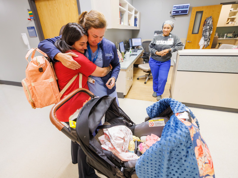 Ashley Meyers hugs Dr. Rachael Morris, associate professor of obstetrics and gynecology, after the first of the quintuplets is discharged from neonatal intensive care. Looking on is LPN Brittney Davis. Melanie Thortis/ UMMC Communications