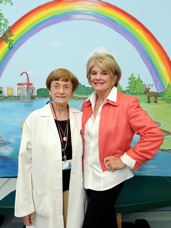 Dr. Jeanette Pullen and Suzan Thames smile under a rainbow mural after the opening of the Center for Cancer and Blood Disorders in this UMMC file photo.