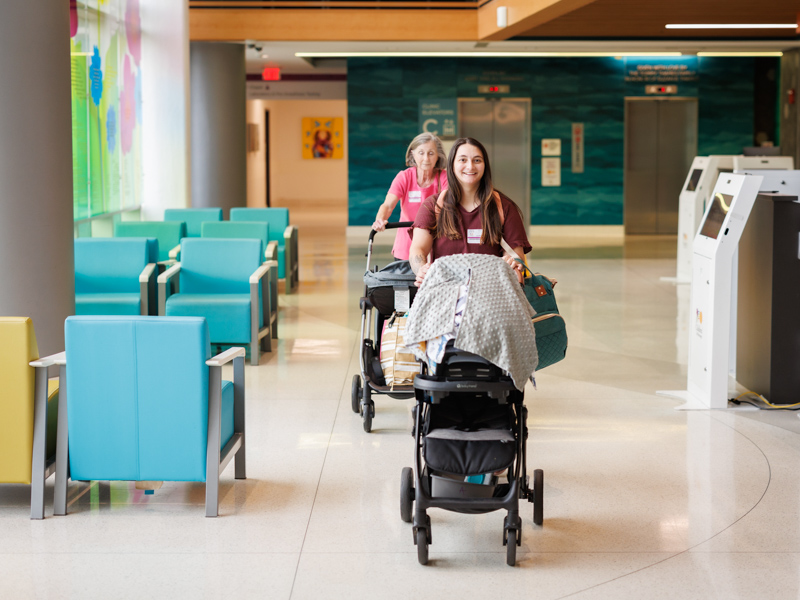 Ashley Meyers and her mother, Sheila Hutchins, wheel Franklin Walker and Saylor Kate through the lobby of the Kathy and Joe Sanderson Tower at Children's of Mississippi. Joe Ellis/ UMMC Communications