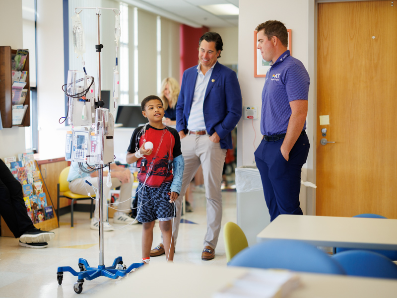 Luke List, right, 2023 winner of the Sanderson Farms Championship, talks with Children's of Mississippi patient Ricardo Davis Jr. of Ridgeland.