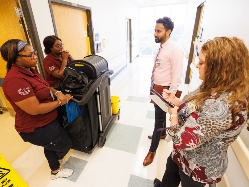 Varang Parikh, executive director of operational excellence, and Rachel Guy, process engineer with Performance Improvement, have an impromptu question-and-answer session with housekeeping contract workers Clarissa Leonard and Lakeisha Scott.