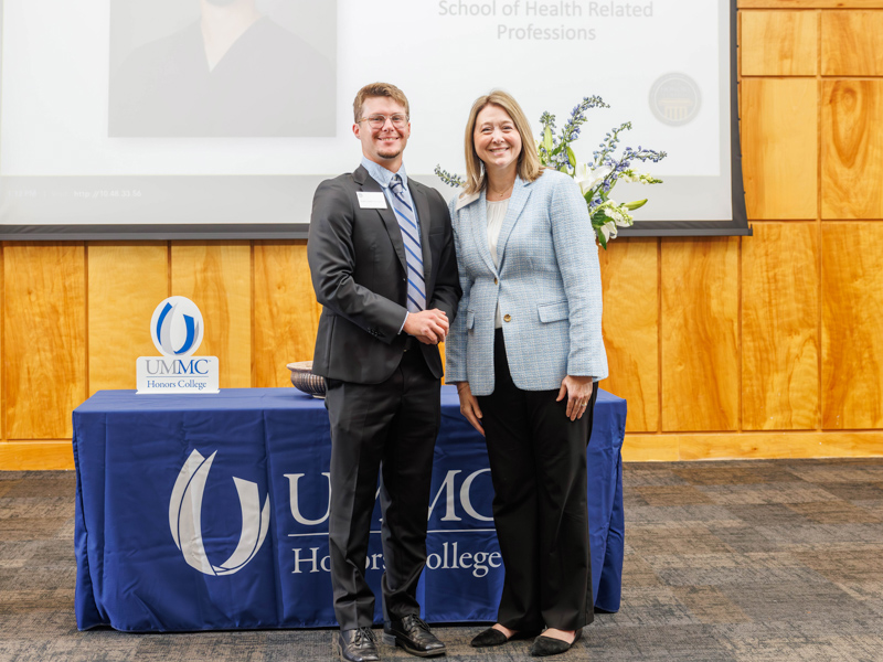 Honors College inductee Kaleb Thompson, a physical therapy student in the School of Health Related Professions, is congratulated by Dr. Natalie Gaughf, assistant vice chancellor for academic affairs.