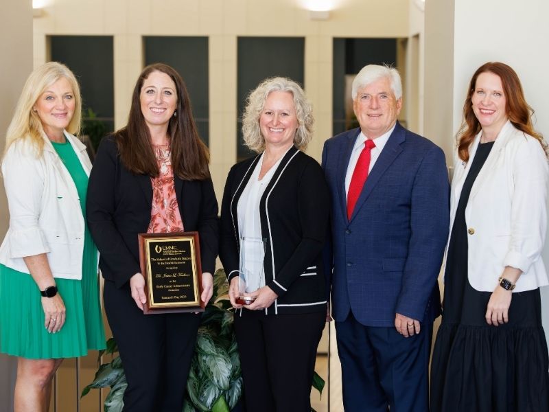 The School of Graduate Studies in the Health Sciences on Friday held its annual Distinguished Alumni Ceremony and Luncheon to honor Drs. Jessica Faulkner and Christine Schnackenberg with alumni awards for 2024. From left are Dr. Babette Lamarca, Faulkner, Schnackenberg, Dr. Joey Granger and Dr. Sydney Murphy. Melanie Thortis/ UMMC Communications