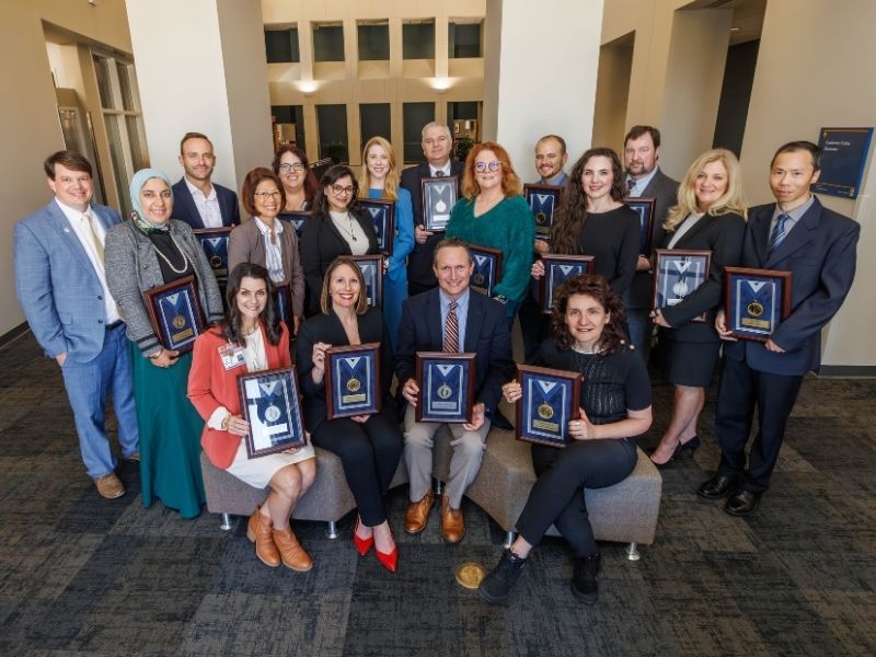 Recipients of the 2024 Office of the Associate Vice Chancellor for Research Excellence Awards present at Friday's ceremony pose with their framed certificates.