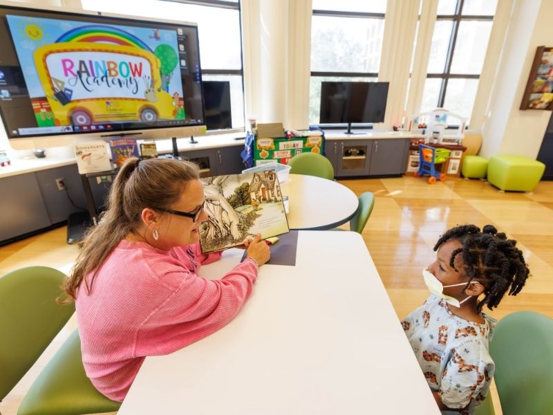 Lori Henry, hospital school teacher, reads to Termondtrez Simmons of Yazoo City during a session of Rainbow Academy at Children's of Mississippi.